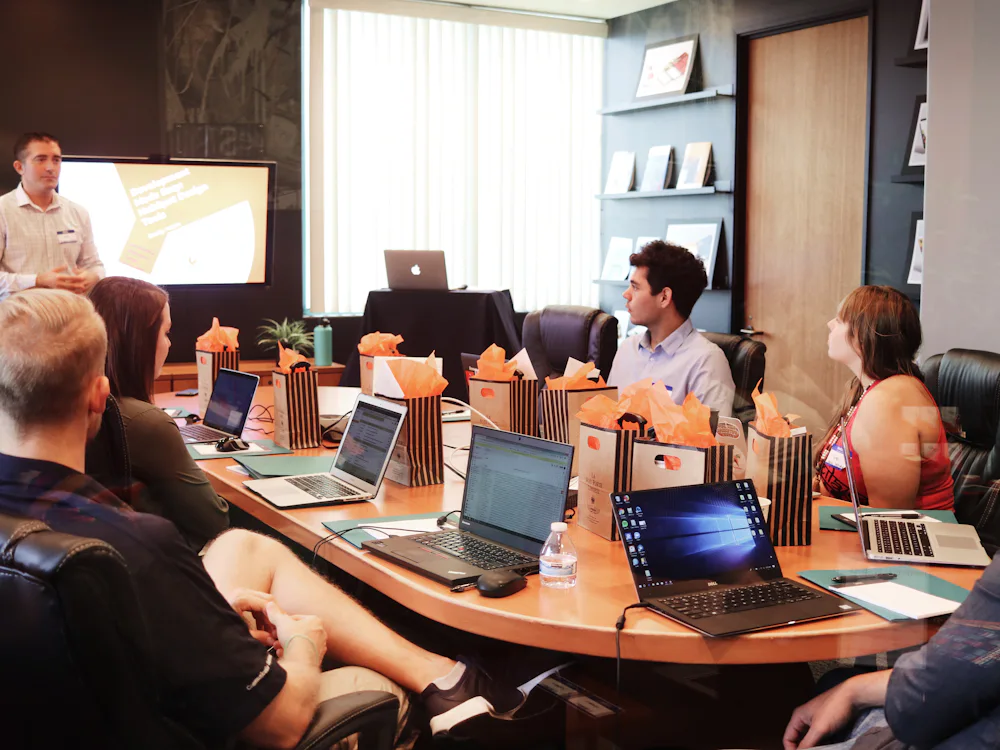 Reunión alrededor de una mesa de trabajo con portátiles